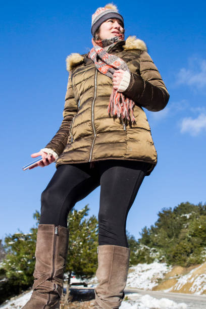 istock Standing Woman With Mobile Phone Feeling Cold 1446679511