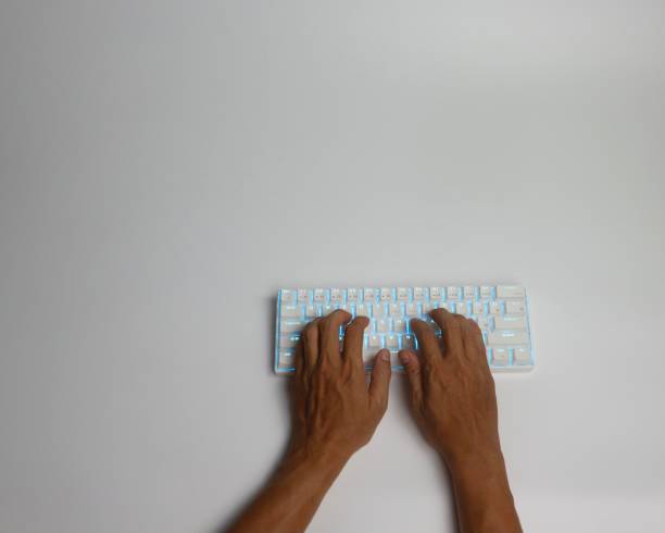 白い背景にアジアの男性の手がブルートゥースの白い機械キーボードで入力 - typewriter key typewriter keyboard blue typebar ストックフォトと画像