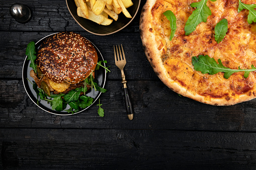 Burger wiech pizza on dark wooden table background with space