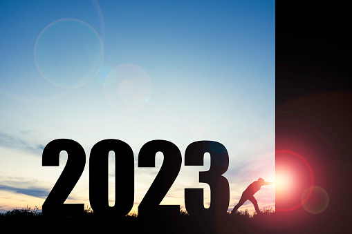 Silhouette of man pushing black scene to open morning scene with blue sky and 2023 year , Preparation merry Christmas and happy new year concept.