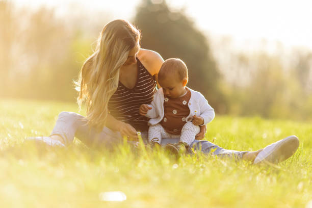 istock Young mother enjoying with her baby outdoors at sunset 1446688419