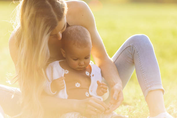 istock Young mother enjoying with her baby outdoors at sunset 1446688439