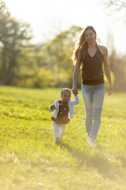 istock Young mother enjoying with her baby outdoors at sunset 1446688486