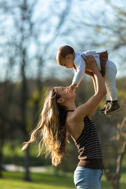 istock Young mother enjoying with her baby outdoors at sunset 1446688487