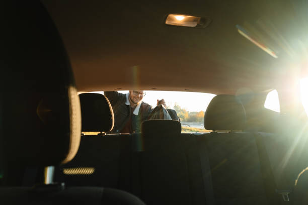 From the inside of the car, a smiling man taking things out of the trunk of the car From inside of car, smiling man taking things out of trunk of car oran algeria photos stock pictures, royalty-free photos & images