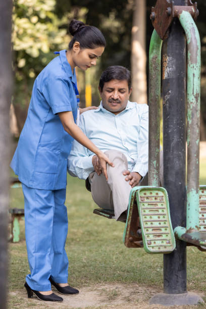 istock Nurse doctor senior care exercise physical therapy ecercising help assistence retirement  elderly man at park. 1446690685