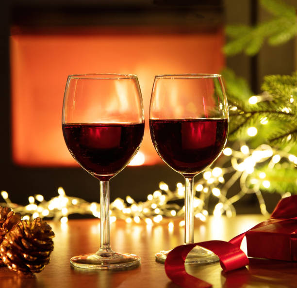 istock Red wine and Christmas decoration on table, fireplace background. Xmas celebration 1446691219