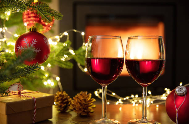 istock Red wine and Christmas decoration on table, fireplace background. Xmas celebration 1446691233