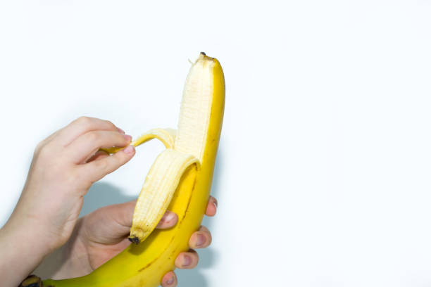 istock Fresh open yellow banana in hand isolated on white 1446691293