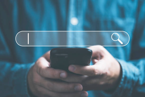 istock Businessman using smartphone to input alphabet in searching bar for Search Engine Optimisation or SEO concept to find information by internet connection. 1446693246