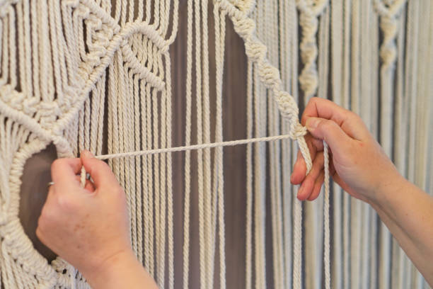 istock Close-up of hand made macrame texture pattern. ECO friendly modern knitting natural decoration concept. Beautiful boho macrame wall panel will add a cozy atmosphere 1446693811