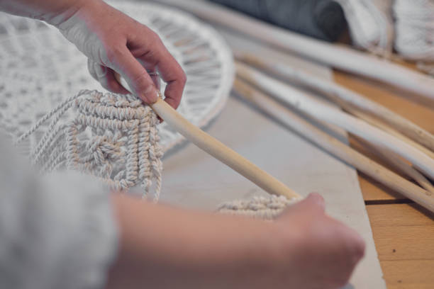 istock woman working on custom macrame decor with tools over a creative desktop watched from above. Hobby knitting macrame of the hand and thread. 1446694548