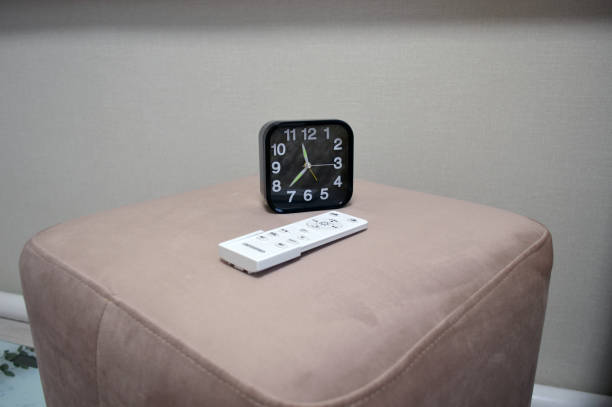istock a black clock sits on the ottoman by the bed in the bedroom with a remote control 1446696253
