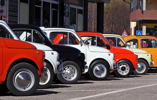 Percoto, Italy. March 24 2019. A row of colorful Fiat 500s in a roadside parking lot, waiting to participate in an auto gathering