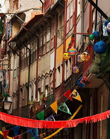 Street feast decorations, rows of multi colored bunting, building exterior facades and roof , windows. Full frame view. Porto , Portugal.