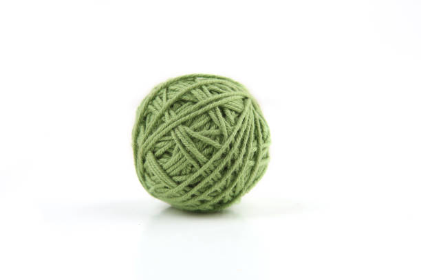 istock Green cotton thread ball isolated on white background. 1446708203