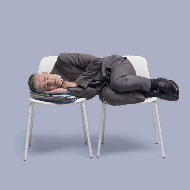 istock Exhausted businessman sleeping on chairs 1446711704