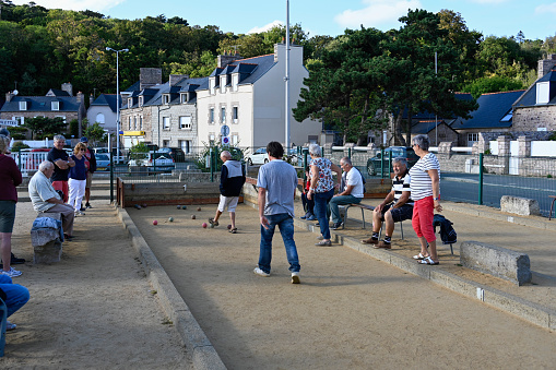 Erquy, France, September 18, 2022 - Boules players on the beach promenade (Rue du Port) of Erquy.
