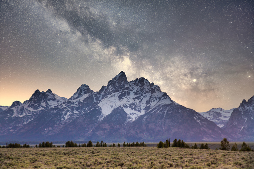 The Grand Teton mountains with a starry night sky.