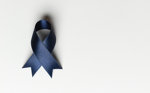 Blue awareness ribbon on white background.