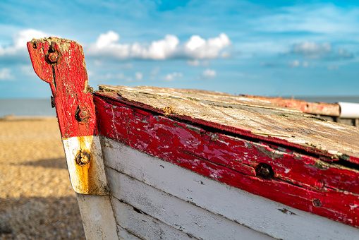 Close-up, shallow focus of the textured front of an old fishing boat. Showing the weathered woodwork and rust.