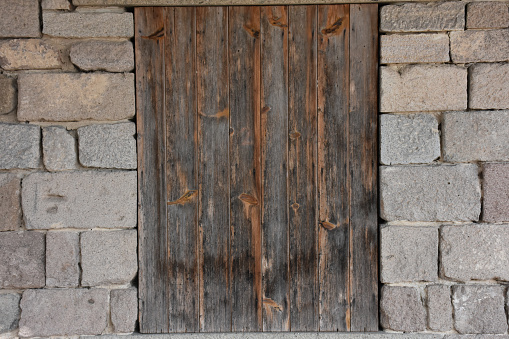 boarded-up door of a barn or house with briquette walls