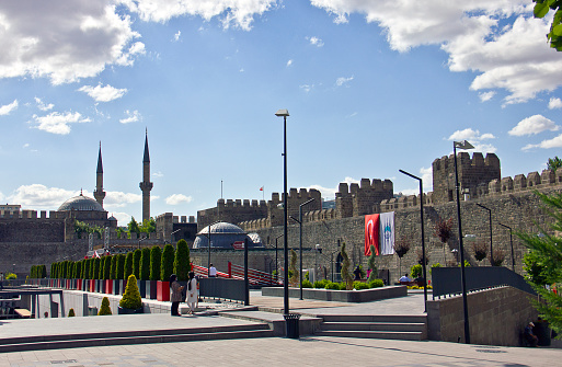 Kayseri, Turkey - July 23, 2021: You can see the traces of 5,000 years in Kayseri Cumhuriyet Square, the heart of the city, in Cumhuriyet Square. You can see the historical heritage of the Byzantine, Seljuk, Ottoman and Republic periods from the castle from the Romans. In the central square of Kayseri, there are many historical settlements such as Kayseri Castle, Kayseri Clock Tower, Bürüngüz Mosque, Kurşunlu Mosque, Hunat Hatun Mosque and Complex, Atatürk statue, Alaca Kümbet, Grand Bazaar and Kazancılar Bazaar, Gevher Nesibe Hatun Madrasa and Şifahane, Zeynel Abidin Tomb. People visit the square and resting in the public park in a sunny day in kayseri.