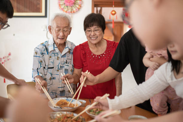 istock Multi generation family celebrates Chinese New Year with a prosperity raw fish Yu Sang 1446720712