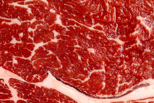 Fresh marble raw beef steak, meat texture close up, macro background. Top view.