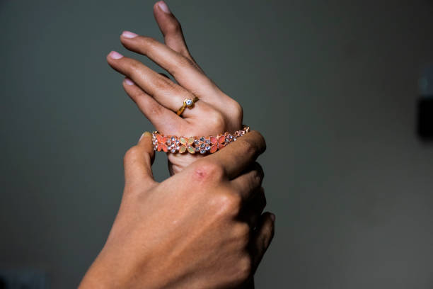 Stock photo of Indian women hand wearing baby pink color designer bangles or bracelet, Picture captured under natural light at Hyderabad,Telangana India. focus on object. blur background. stock photo