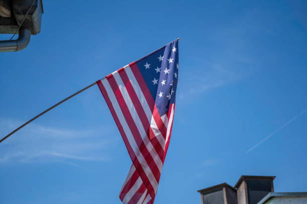 istock flag flies against a blue white sky 1446725431