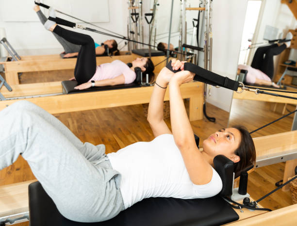 istock Sportswoman stretching body on pilates chair while doing forward bends during workout 1446728171