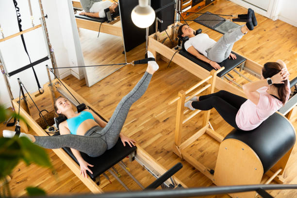 istock Fitness studio with women practicing Pilates on reformer 1446728193