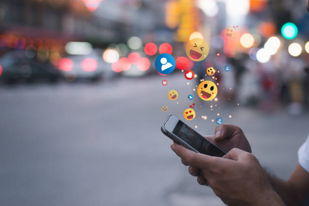istock Young man sending emojis on his smartphone. Emoticon emoticon text messaging using a mobile phone. 1446728274