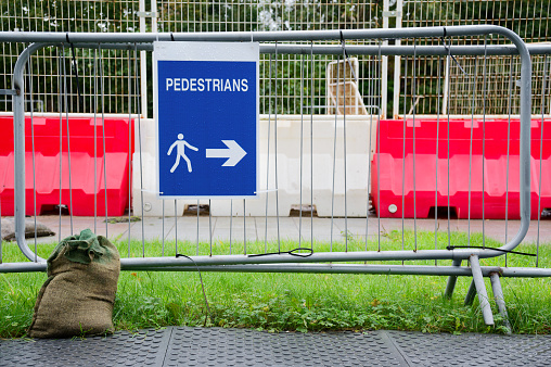 Pedestrian walkway sign at construction building site fence UK