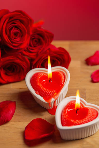 istock red roses with burning candles on red background 1446729819