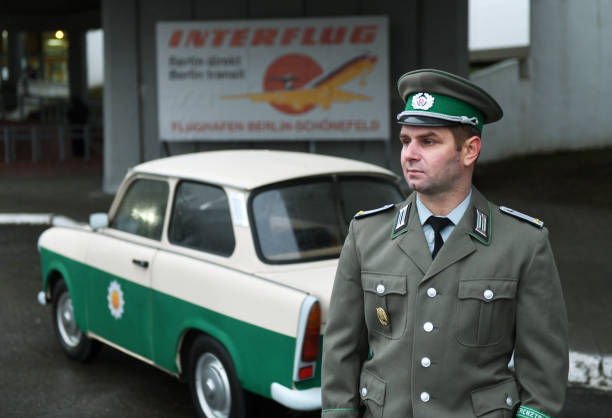 レトロなパトカートラバントの近くの東ベルリンからの国境警備隊。インターフルークは、ドイツ民主共和国の国営航空会社であるパトカーのトラバント(トラビ)601aです。 - 1988 ストックフォトと画像