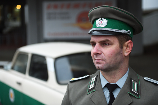 Belarus, Minsk - 30.11.2022:A border guard from East Berlin near a retro police car Trabant. Interflug is the state-owned airline of the German Democratic Republic.Police car Trabant (Trabi) 601a.