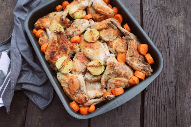 istock Roasted Rabbit Haunches in Pan with Stewed Vegetables on Rustic Wooden Table Surface 1446735662