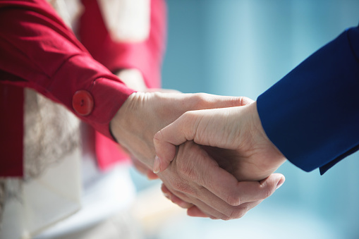 Close-up of unrecognizable people shaking hands with a very dear person