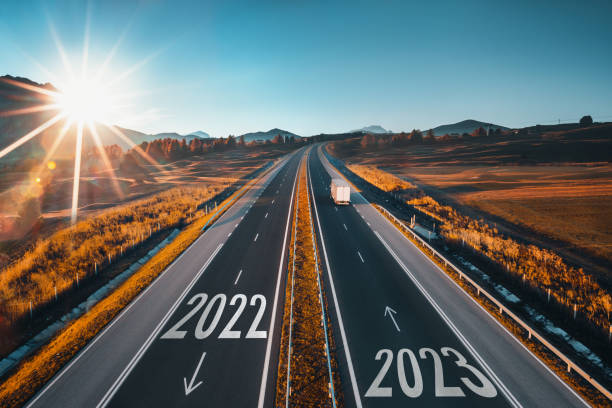 2023 Happy New Year text on the road, concept for trip travel and future vision for successful start straight, planning and challenge or career path,business strategy,opportunity and change, new goals. Highway road and nature landscape. texto de feliz año nuevo 2023 en el camino, concepto para viajes de viaje y visión futura para un comienzo exitoso, planificación y desafío o trayectoria profesional, estrategia comercial, oportunidad y cambio, nuevos objetivos. carretera de autopista