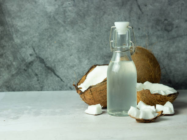 istock fresh refreshing Coconut water in a bottle with an open coconut with white pulp on a concrete background. 1446738022