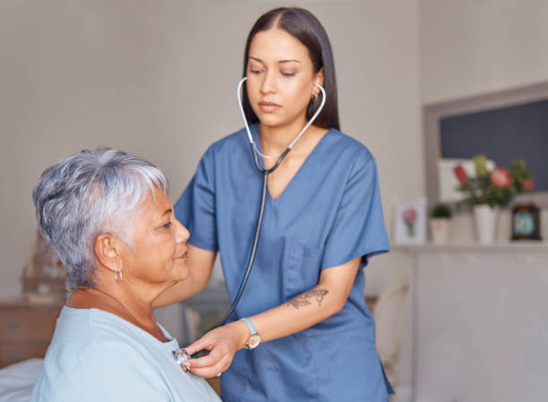 elderly patient, nursing and nurse with a stethoscope listening to heartbeat during a health consultation. healthcare professional, senior woman and medical checkup in her room at the retirement home - ouvindo batidas do coração imagens e fotografias de stock