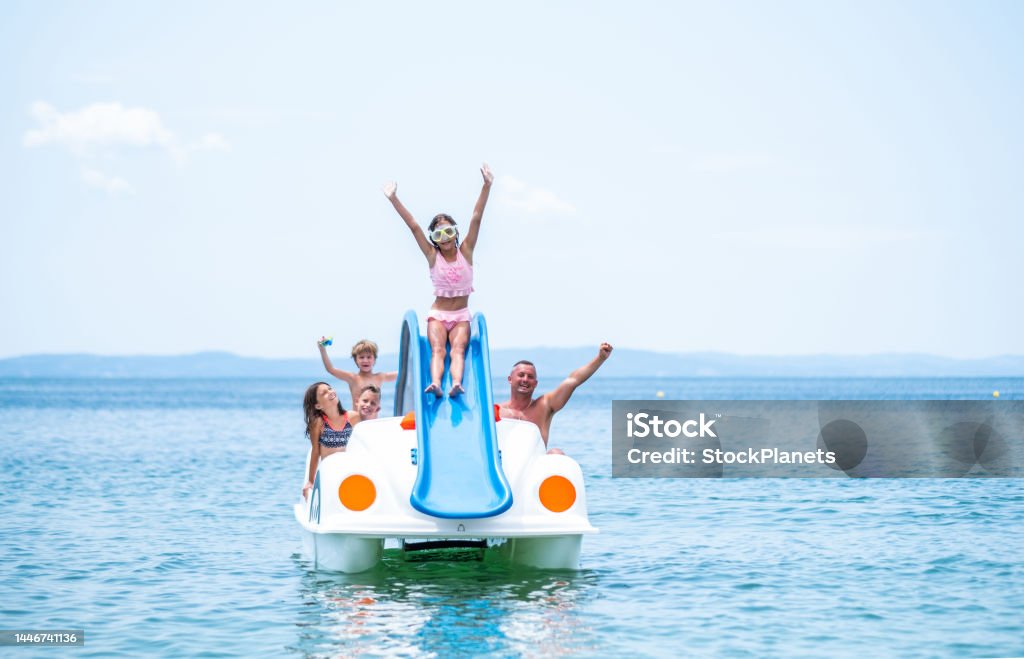 Family enjoys at paddleboat Happy family have fun together riding paddleboat Adult Stock Photo