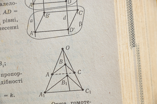 geometry drawing on page of old yellow book as background, algebra book as background