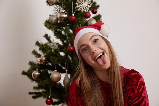 Beautiful Russian girl and christmas tree with hat gift packages star fun joy studio white background