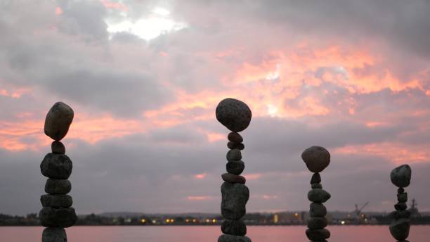 istock Rock balancing and cloudy dramatic sky on sunset. Stack of stones in balance. 1446743414