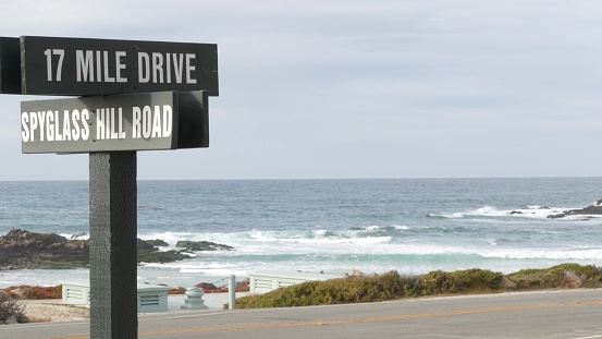 Scenic 17-mile drive wooden road sign, Monterey, California, USA. Roadtrip along sea ocean. Pacific coast highway tourist trip route. Ecotourism on vacations near Point Lobos, Big Sur and Pebble beach
