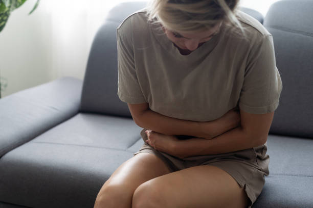 istock Young casual woman is having stomach ache. 1446745481
