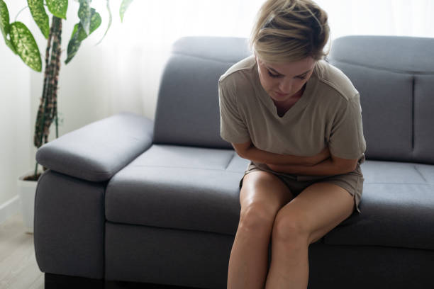 istock Young casual woman is having stomach ache. 1446745661